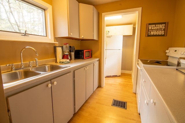 43 Parker Ledge Rd, Woodstock, NH 03262 - kitchen with white appliances, a sink, light countertops, light wood finished floors, and white cabinetry
