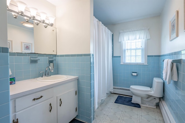 bathroom featuring tile walls, a baseboard heating unit, a wainscoted wall, toilet, and vanity