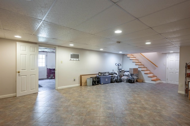 below grade area with baseboards, stairs, a drop ceiling, and recessed lighting