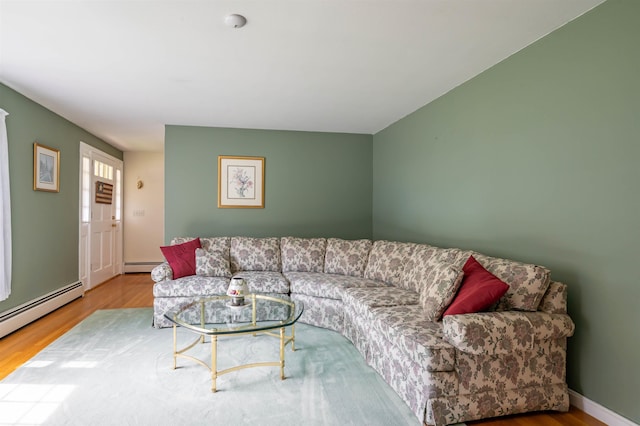 living area with a baseboard heating unit and wood finished floors