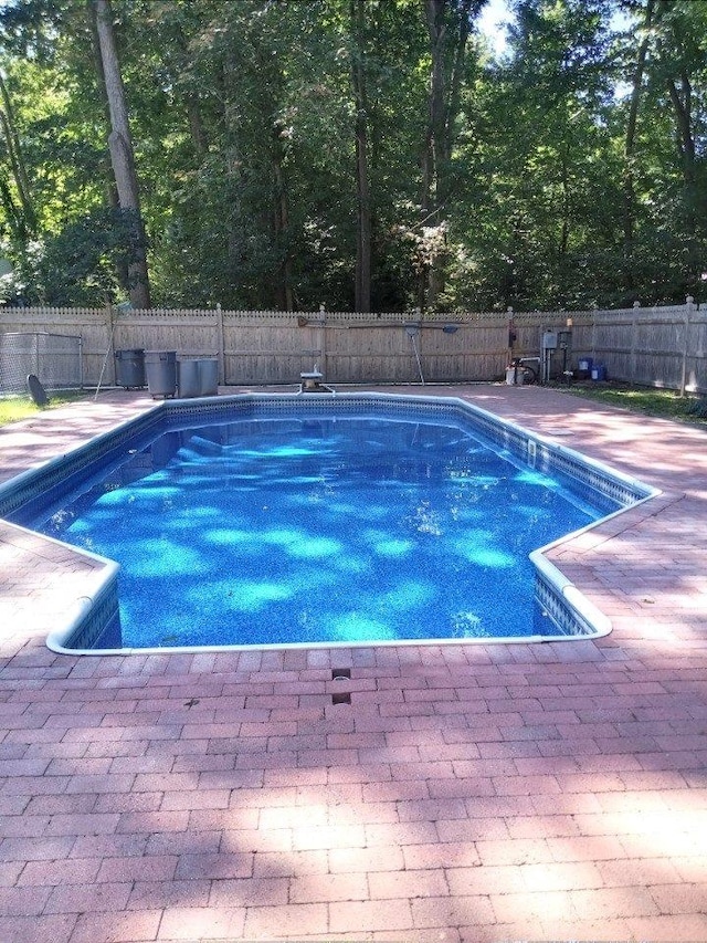 view of swimming pool with a fenced backyard and a patio