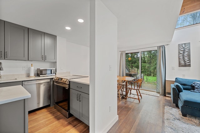 kitchen featuring stainless steel appliances, gray cabinetry, a sink, healthy amount of natural light, and recessed lighting