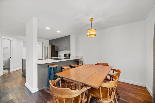 dining space featuring dark wood finished floors, recessed lighting, and baseboards