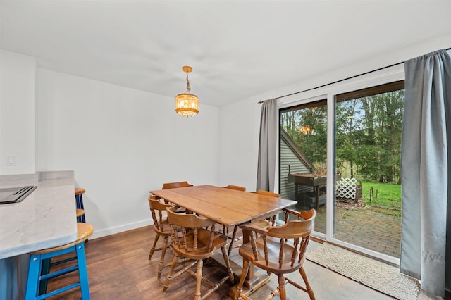 dining space featuring baseboards and wood finished floors