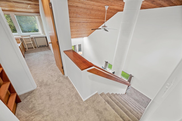 stairs featuring wood ceiling, carpet floors, a ceiling fan, and vaulted ceiling