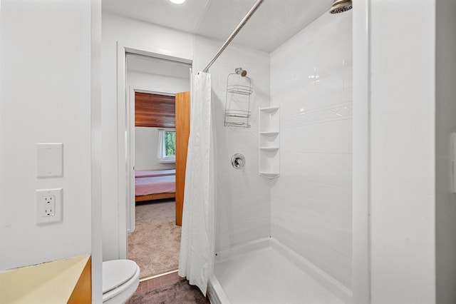 full bathroom featuring a tile shower and toilet