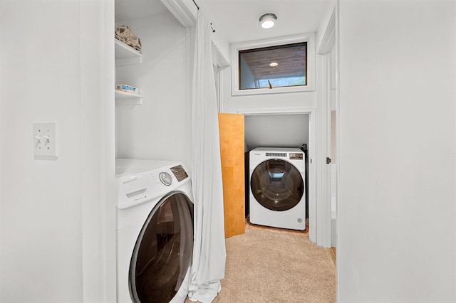clothes washing area with washer / clothes dryer and light colored carpet