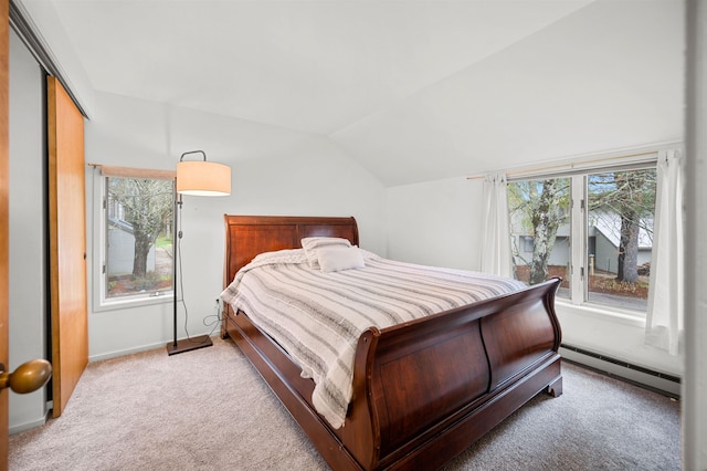 bedroom featuring baseboard heating, vaulted ceiling, carpet, a closet, and baseboards
