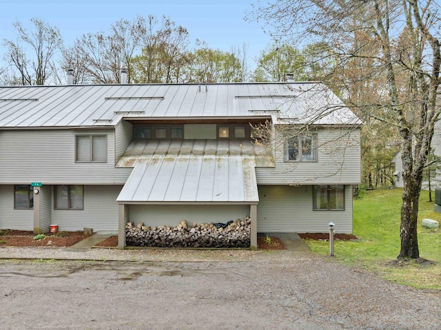 view of front of home featuring a standing seam roof, metal roof, and a front lawn