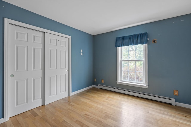 56 Call Rd, Webster, NH 03303 - unfurnished bedroom with a baseboard radiator, wood finished floors, baseboards, and a closet