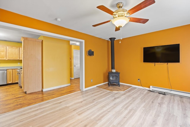 56 Call Rd, Webster, NH 03303 - unfurnished living room with light wood finished floors, a wood stove, baseboards, and a ceiling fan