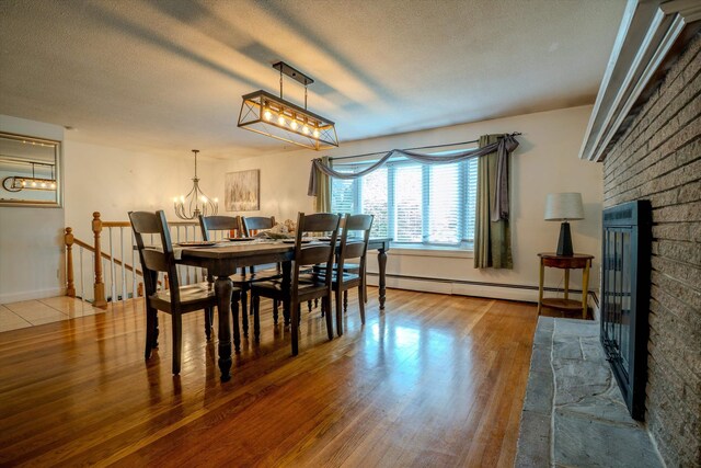 1 Alpine Rd, Windham, NH 03087 - dining area with a baseboard heating unit, wood finished floors, a chandelier, a textured ceiling, and baseboards
