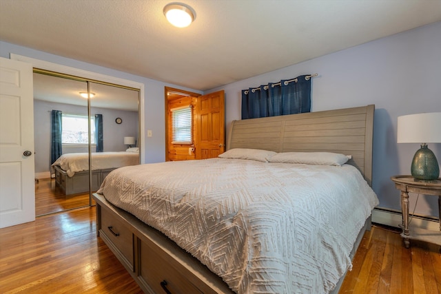 1 Alpine Rd, Windham, NH 03087 - bedroom with baseboard heating, hardwood / wood-style flooring, and a closet