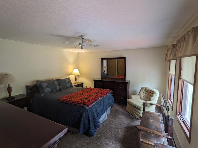 bedroom featuring dark colored carpet, a ceiling fan, crown molding, and a textured ceiling