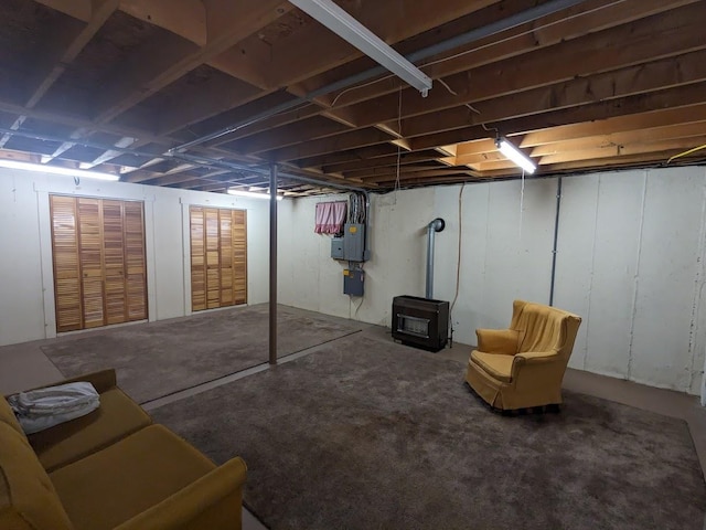 unfinished basement featuring a wood stove and electric panel