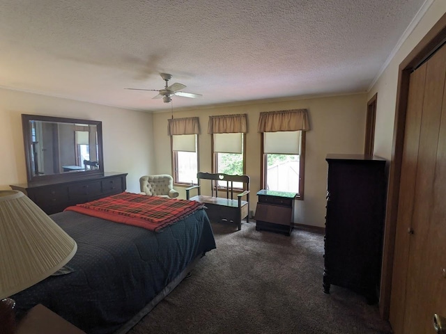 bedroom featuring dark colored carpet, a textured ceiling, and a ceiling fan