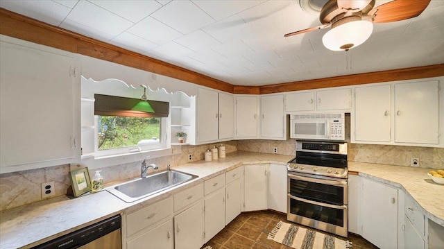kitchen featuring stainless steel appliances, a sink, light countertops, tasteful backsplash, and white cabinets