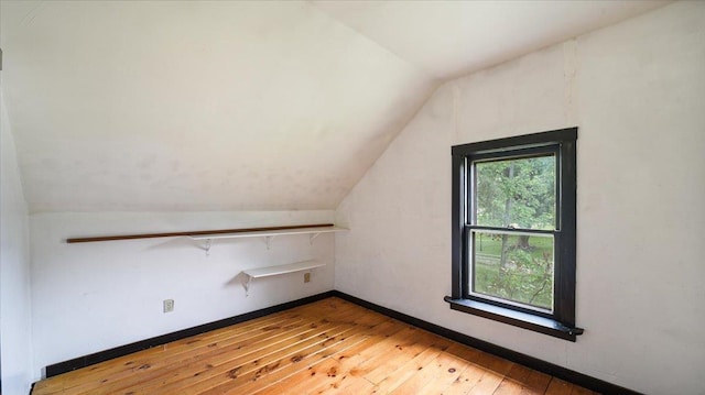 bonus room with hardwood / wood-style flooring, lofted ceiling, and baseboards