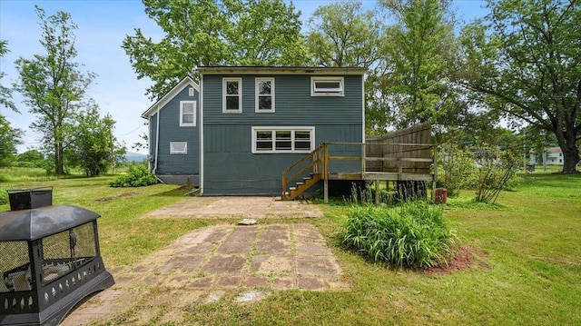 back of property featuring a yard, a deck, and stairway