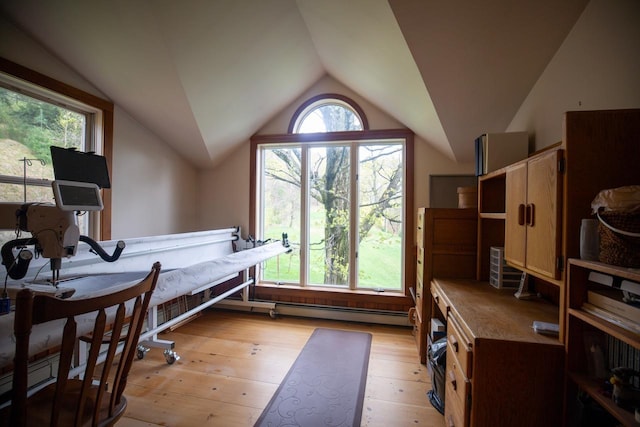 bedroom with vaulted ceiling, light wood finished floors, and a baseboard radiator