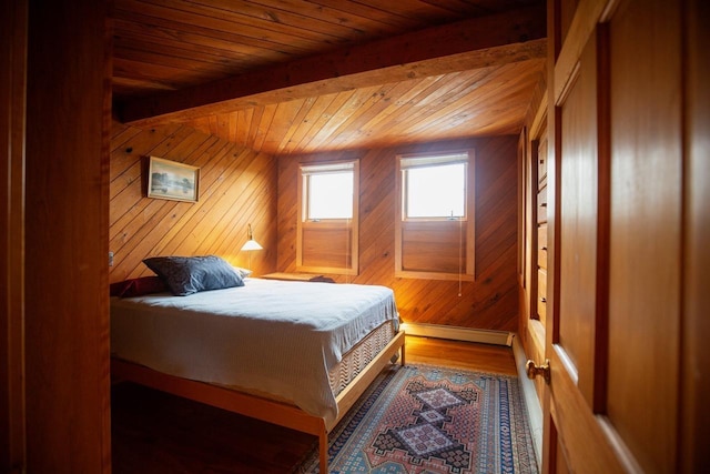 bedroom featuring wooden walls, beamed ceiling, a baseboard radiator, wooden ceiling, and wood finished floors