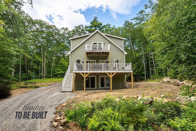 rear view of property with a balcony, french doors, stairway, and a deck