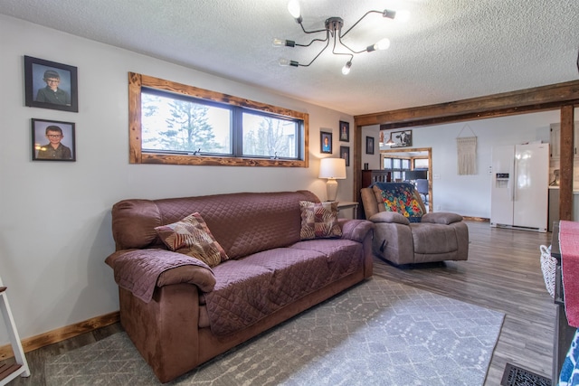 7206 S Wheelock Rd, Wheelock, VT 05851 - living room with a chandelier, a textured ceiling, wood finished floors, and baseboards