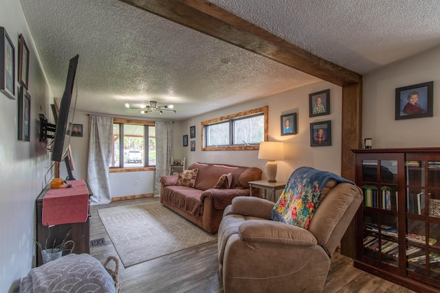 7206 S Wheelock Rd, Wheelock, VT 05851 - living area featuring a textured ceiling, wood finished floors, a chandelier, baseboards, and beamed ceiling