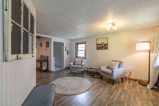 7206 S Wheelock Rd, Wheelock, VT 05851 - sitting room featuring wood finished floors, a textured ceiling, baseboards, and wooden walls