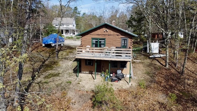 back of property with a deck and log exterior