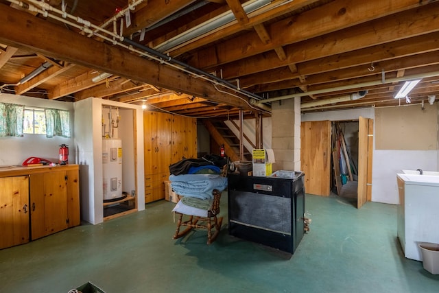 below grade area featuring water heater, stairs, and washer / dryer