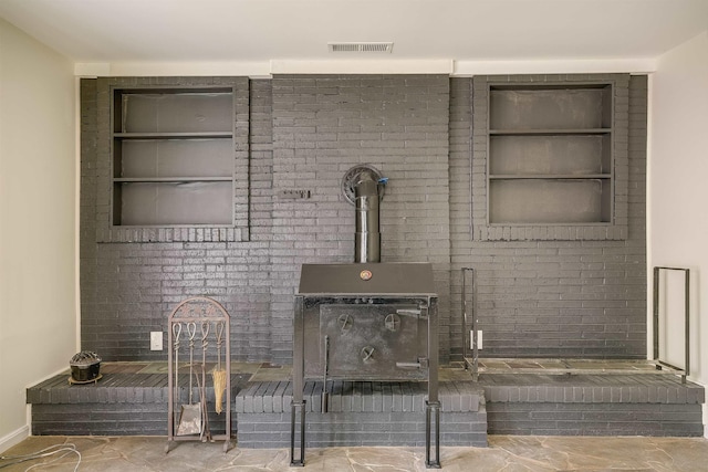 detailed view of built in shelves, a wood stove, and baseboards