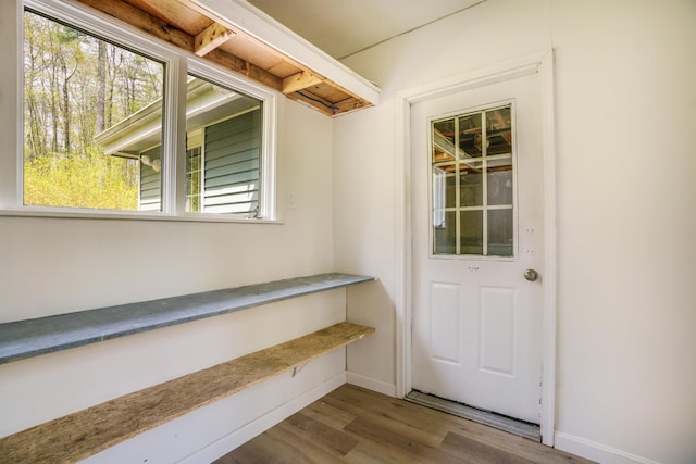 doorway with wood finished floors and baseboards