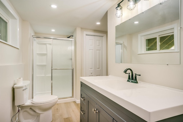 full bathroom with wood finished floors, a shower stall, toilet, recessed lighting, and vanity