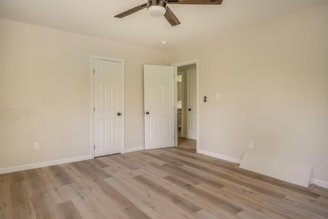 unfurnished bedroom with light wood-style flooring, baseboards, and a ceiling fan