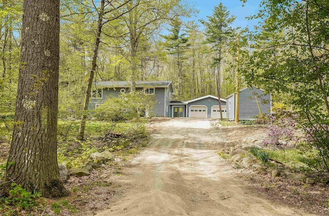 view of front of house with an attached garage, driveway, and an outbuilding