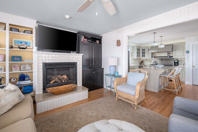 150 Webhannet Dr, Wells, ME 04090 - living area with light wood-type flooring, a tile fireplace, and a ceiling fan