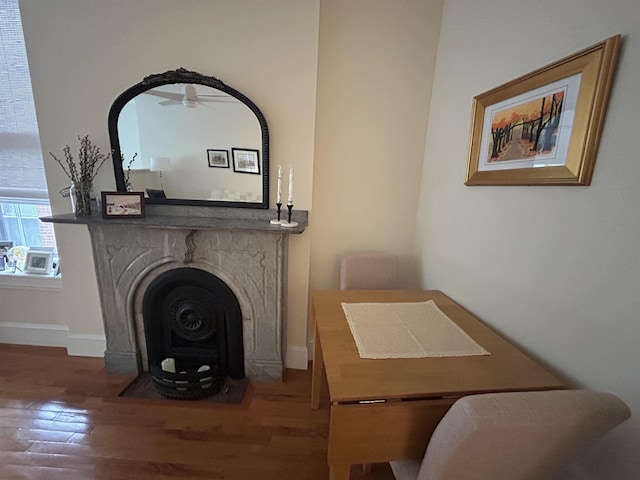 detailed view of a fireplace with flush hearth, wood finished floors, and baseboards