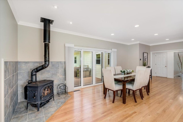 371 Tibbetts Hill Rd, Goffstown, NH 03045 - dining area featuring a wood stove, light wood-type flooring, recessed lighting, tile walls, and ornamental molding