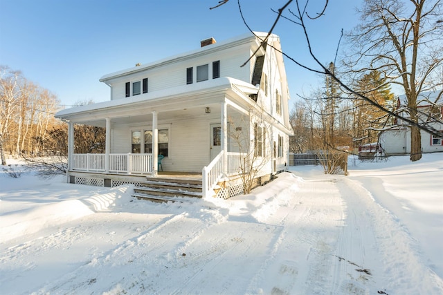 view of front facade with a porch and a chimney