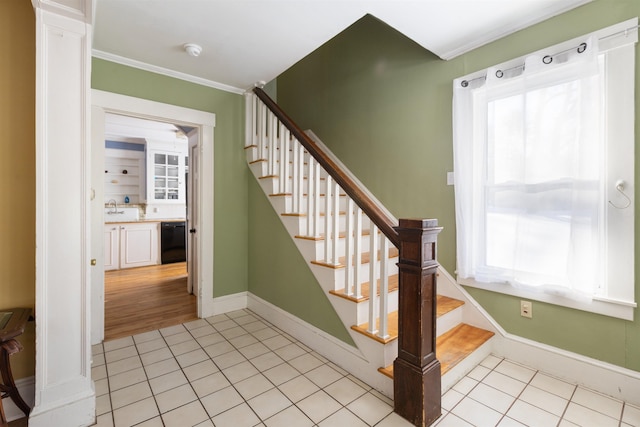 stairs with tile patterned flooring, crown molding, decorative columns, and baseboards