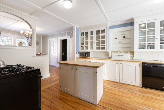 kitchen with black appliances, a sink, wood counters, open shelves, and light wood-style flooring