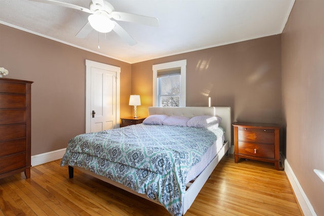 bedroom with baseboards, light wood-style floors, ornamental molding, and ceiling fan