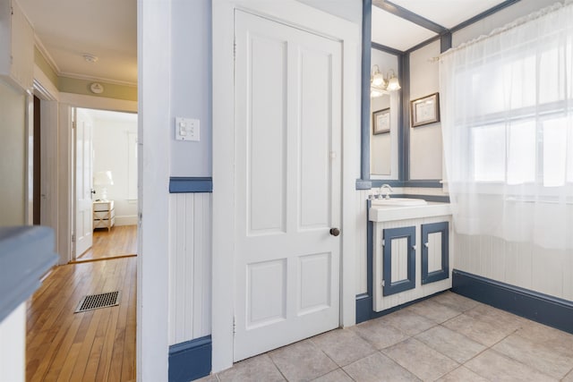 bathroom featuring crown molding, vanity, and wood finished floors