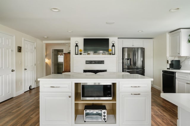 kitchen featuring stainless steel appliances, dark wood finished floors, light countertops, white cabinetry, and baseboards