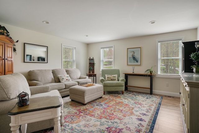 living area with plenty of natural light, light wood finished floors, baseboards, and recessed lighting