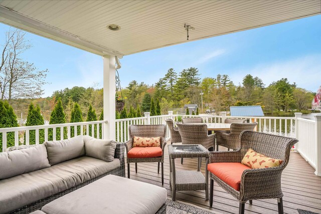 deck with an outdoor hangout area, outdoor dining area, a shed, and an outdoor structure
