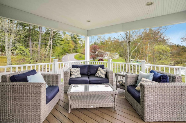 wooden terrace featuring an outdoor living space and view of scattered trees