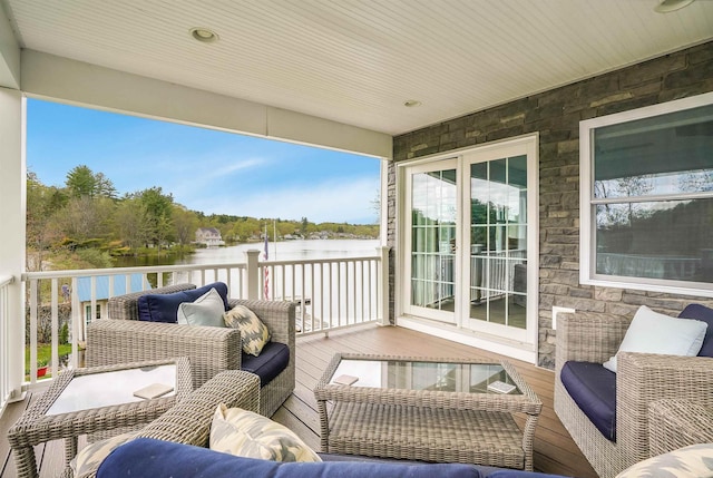 balcony with a water view and an outdoor living space