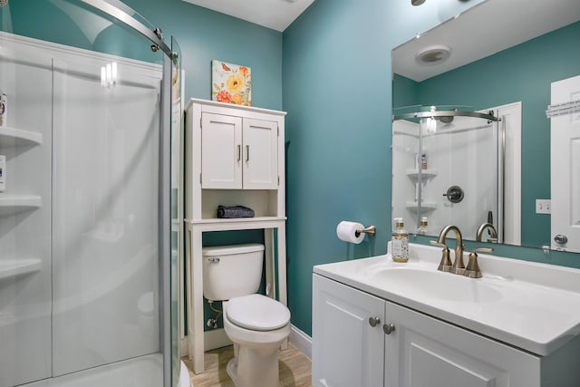 full bath featuring a stall shower, wood finished floors, toilet, and vanity
